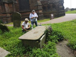 two people recording details of a tomb